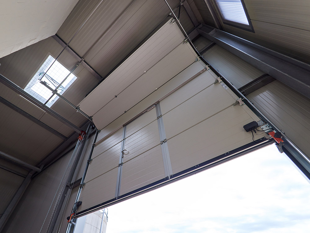 Stahlhalle mit industriellem Sektionaltor Innenansicht einer Stahlhalle mit großem Sektionaltor als Beispiel für modernen Stahlbau